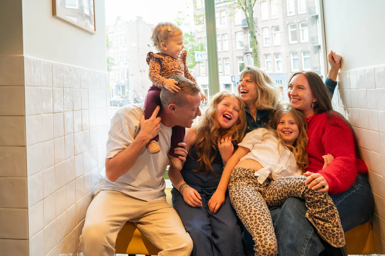 A family laughing together in the window booth