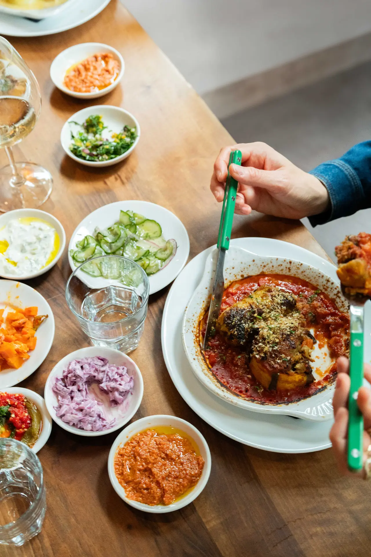 Garden vegetables filled with rice and lentils, surrounded by small salads and dips