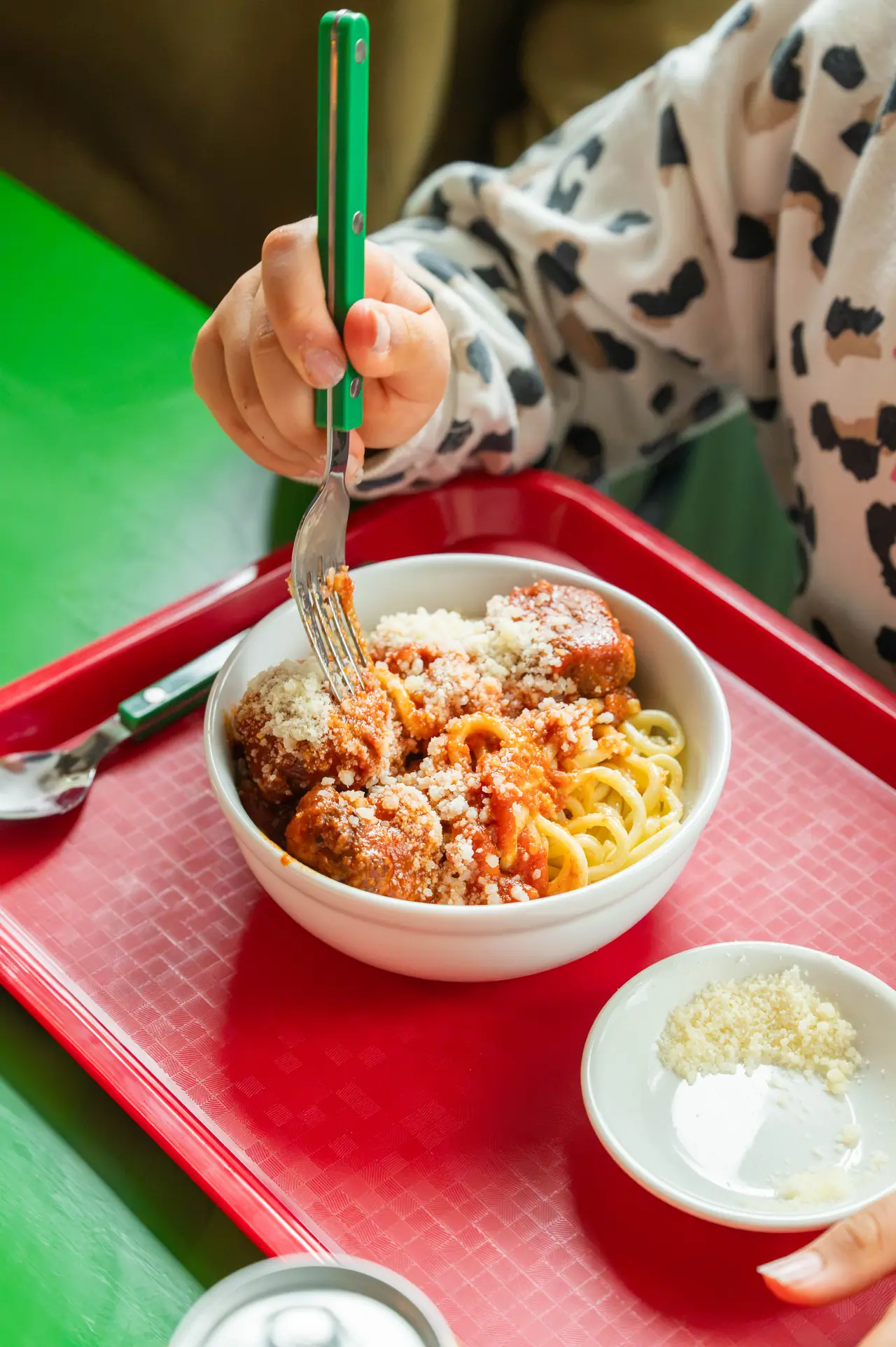 Meatballs with spaghetti and parmesan on a red tray