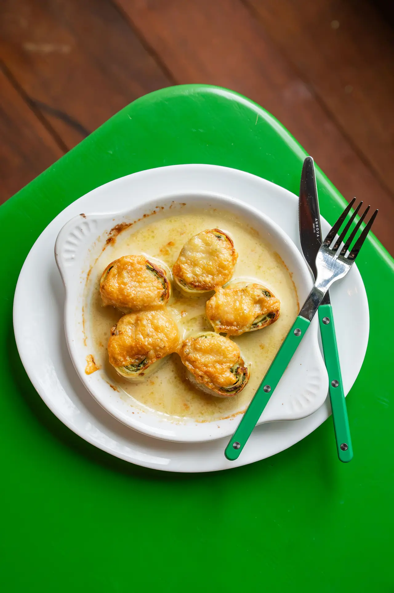 Rotolo pasta filled with ricotta and spinach on a green table