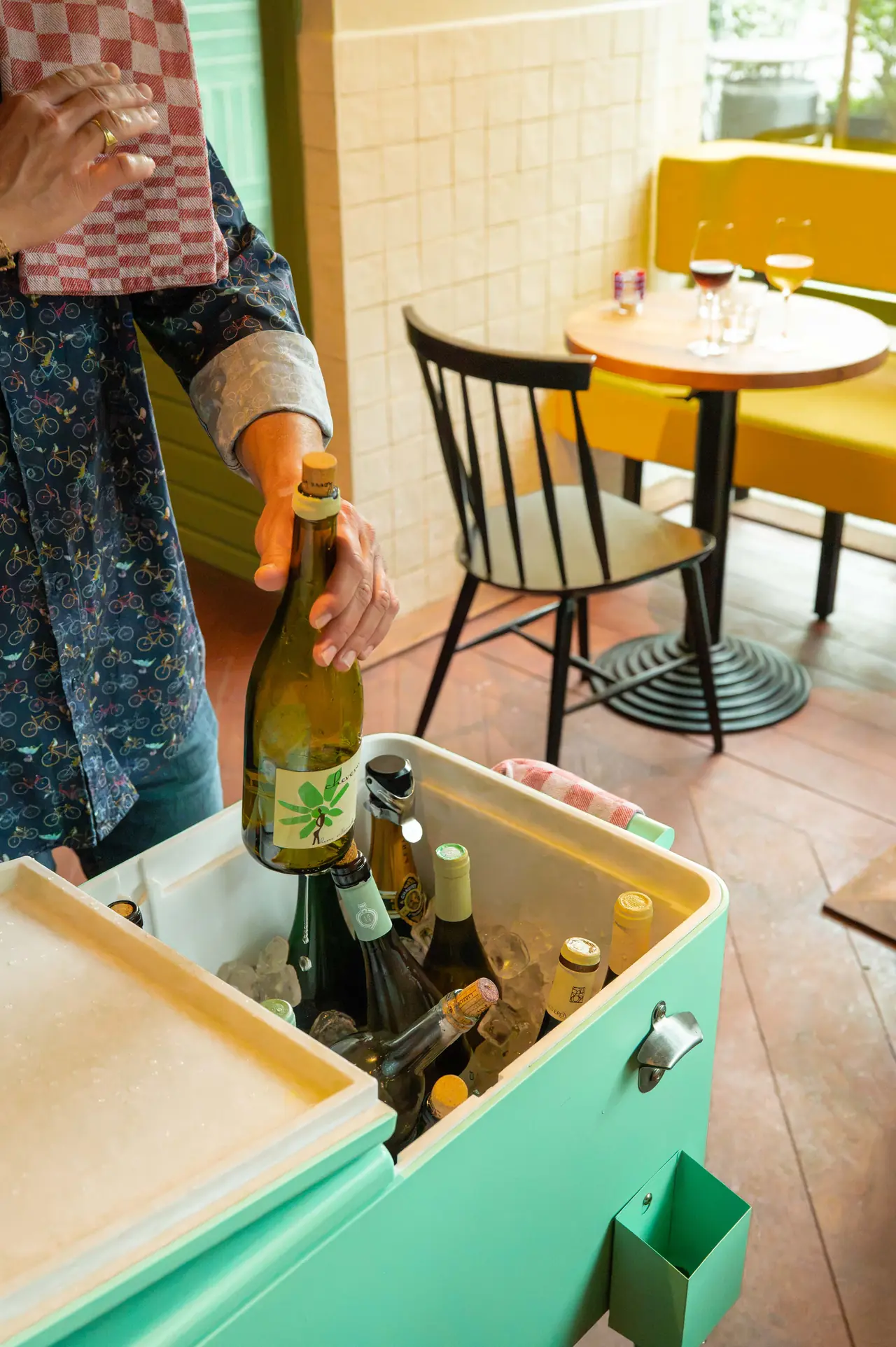 Picking a bottle from the green wine cooler